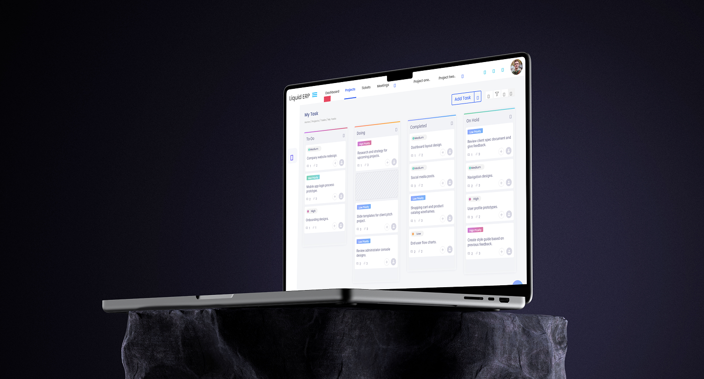 Liquid ERP dashboard shown on a laptop resting on a stool